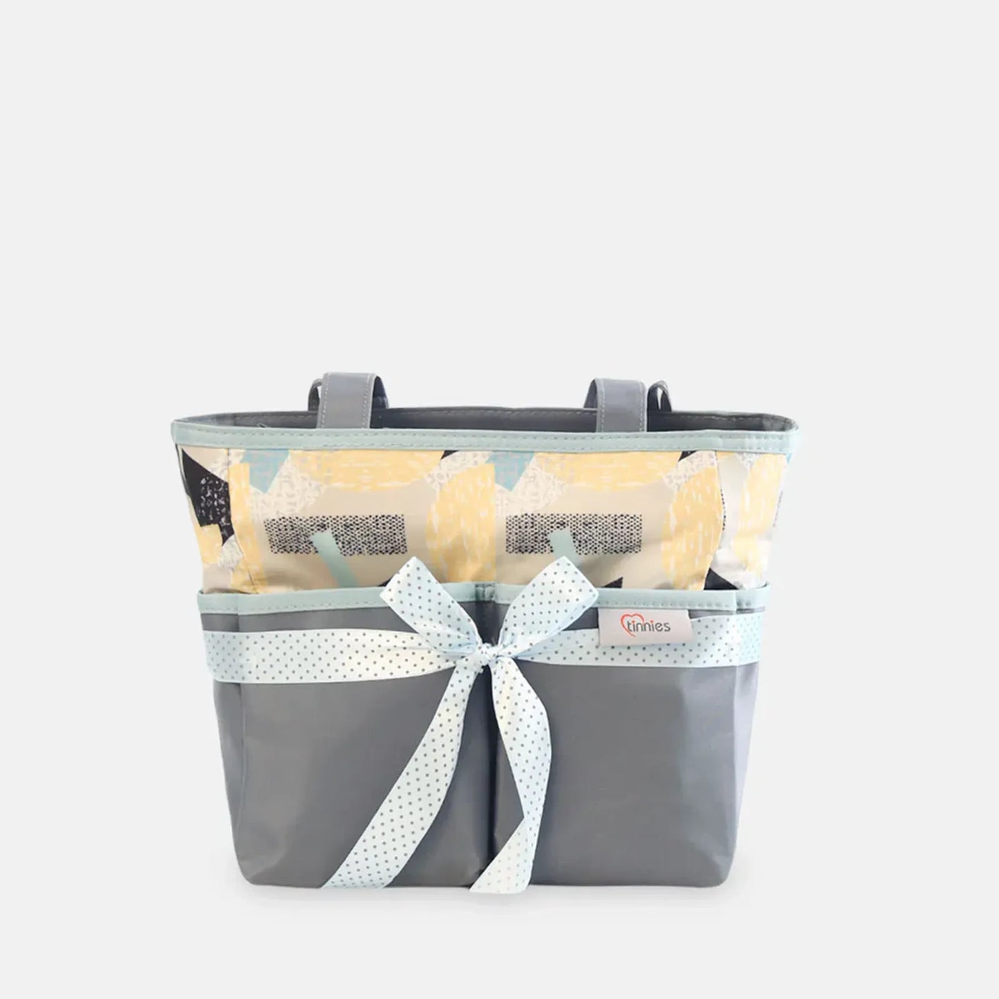 Gray basket with a white ribbon and yellow flowers on a light gray background