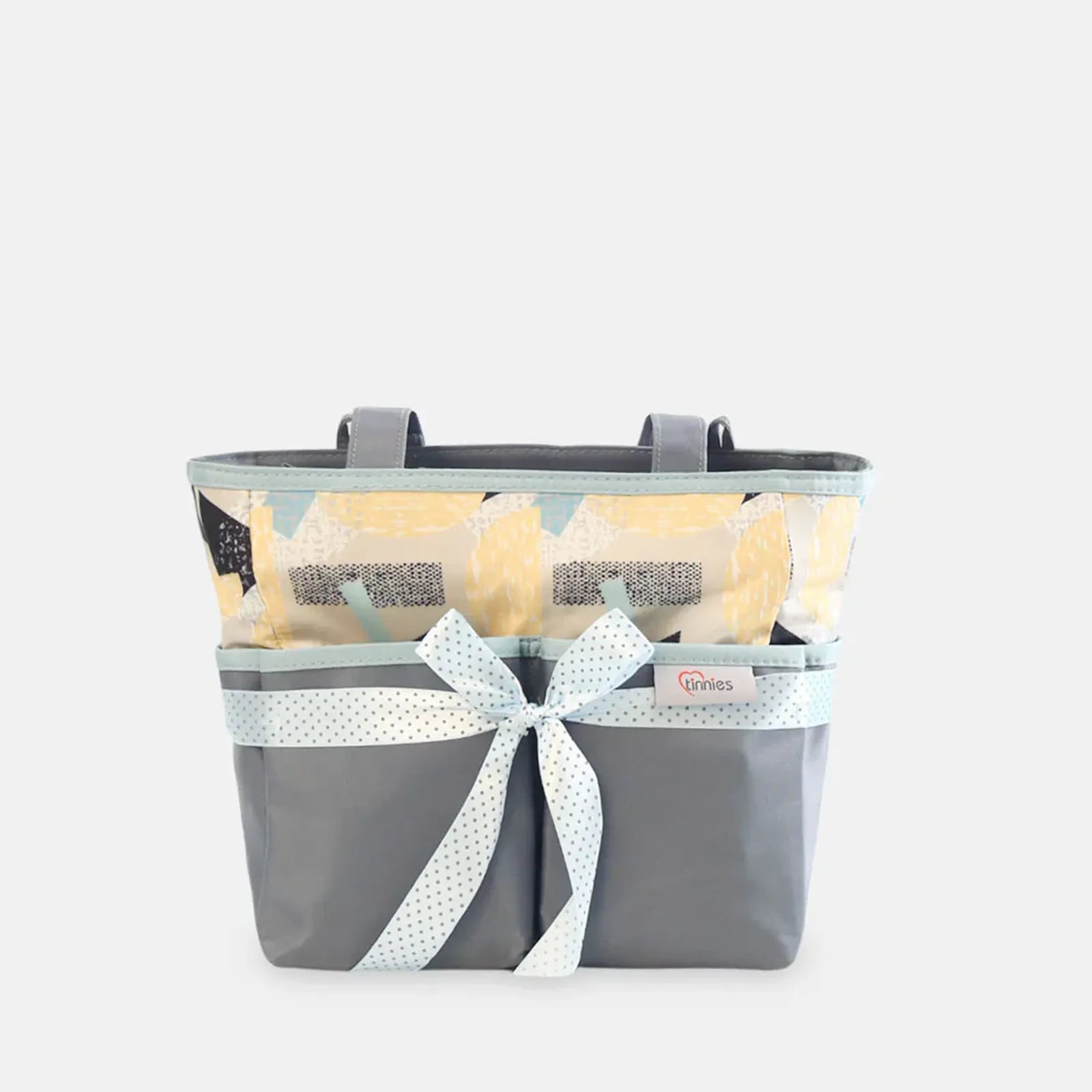 Gray basket with a white ribbon and yellow flowers on a light gray background