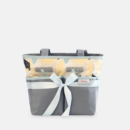 Gray basket with a white ribbon and yellow flowers on a light gray background