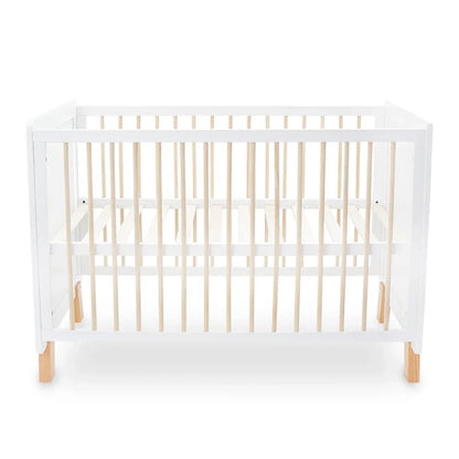 White crib with wooden legs and sides on a white background