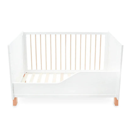 White crib with wooden slats on a white background